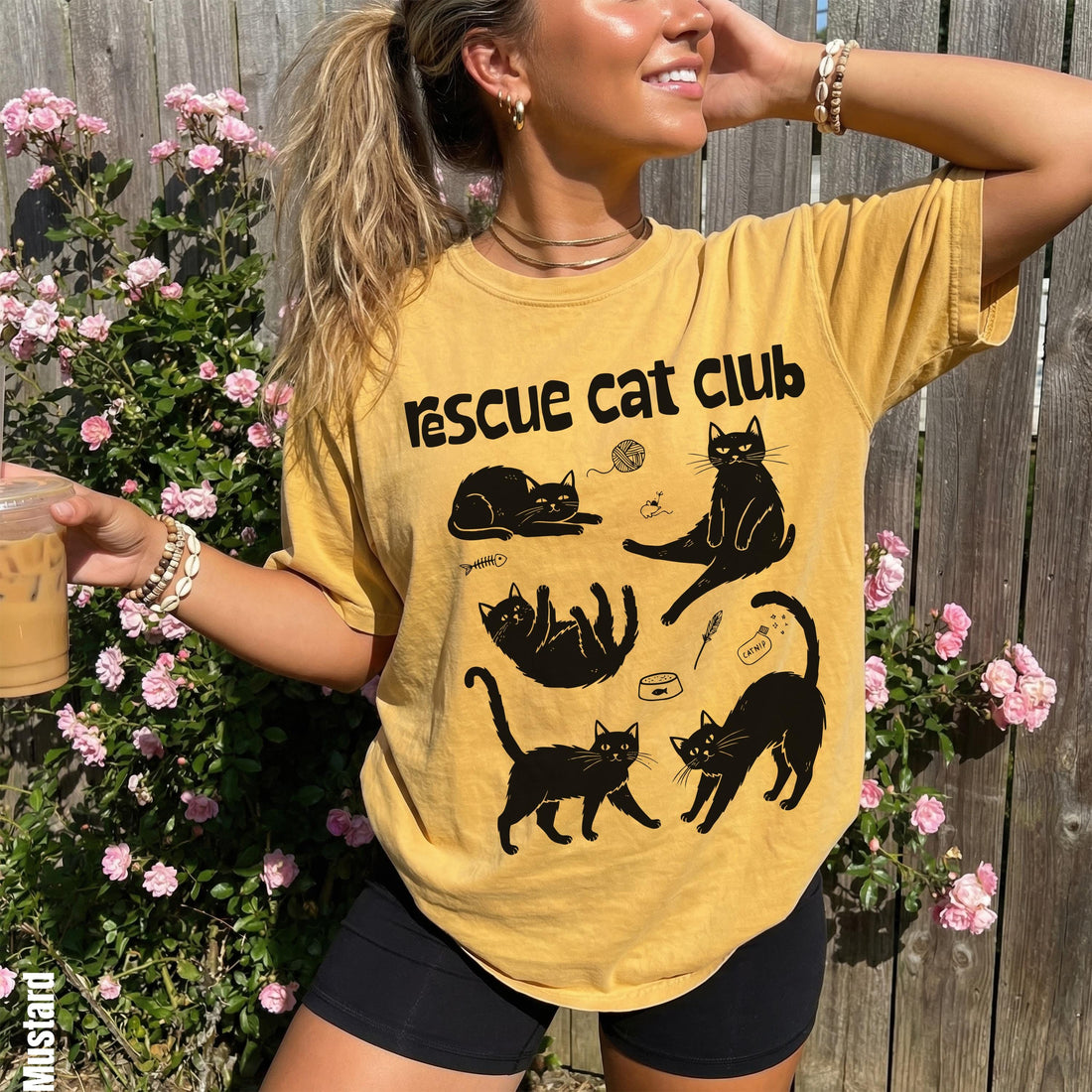 Yellow graphic t-shirt with black cat designs and text.