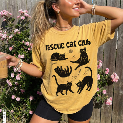 Yellow graphic t-shirt with black cat designs and text.