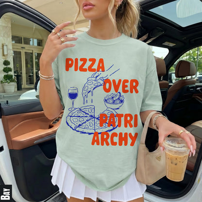 T-shirt with &amp;quot;Pizza Over Patriarchy&amp;quot; text and pizza graphic, held by a person in a car.