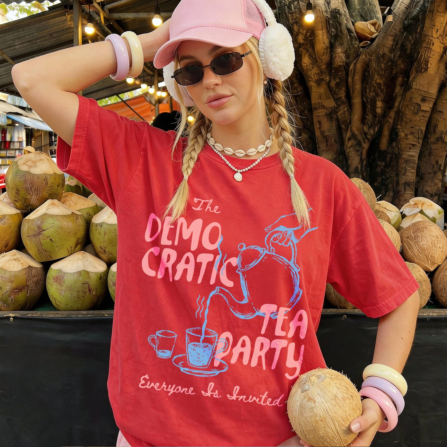 Girl in red t-shirt with &amp;quot;Democratic Tea Party&amp;quot; graphic, wearing pink hat and holding coconut.