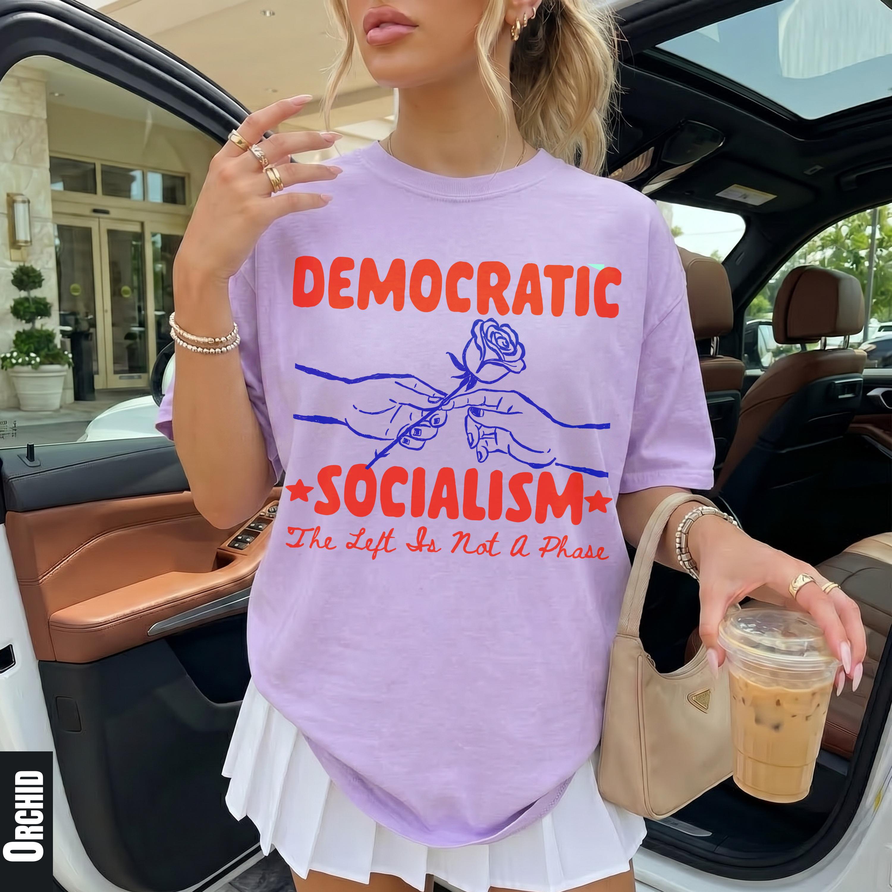 Light purple t-shirt with &amp;quot;DEMOCRATIC SOCIALISM&amp;quot; text, hands holding a rose, and the phrase &amp;quot;The Left Is Not a Phase&amp;quot;.