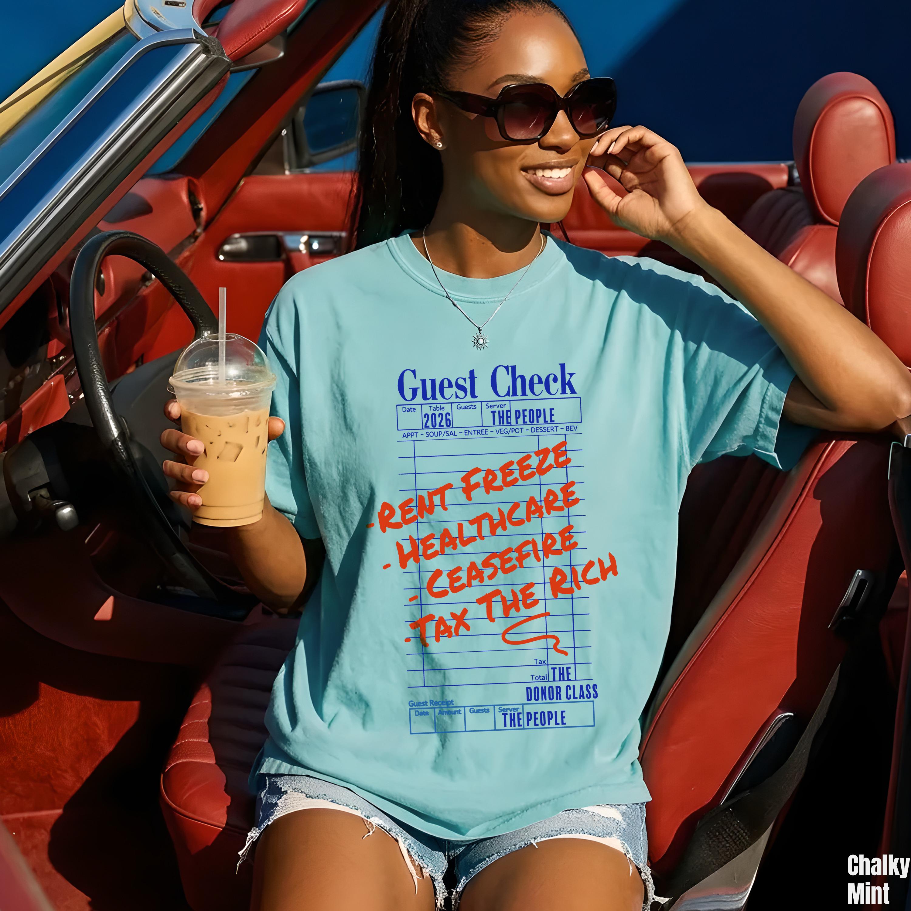 Teal graphic t-shirt with &amp;quot;Guest Check&amp;quot; design, &amp;quot;Rent Freeze&amp;quot;, &amp;quot;Healthcare&amp;quot;, &amp;quot;Ceasefire&amp;quot;, &amp;quot;Tax The Rich&amp;quot; slogans.