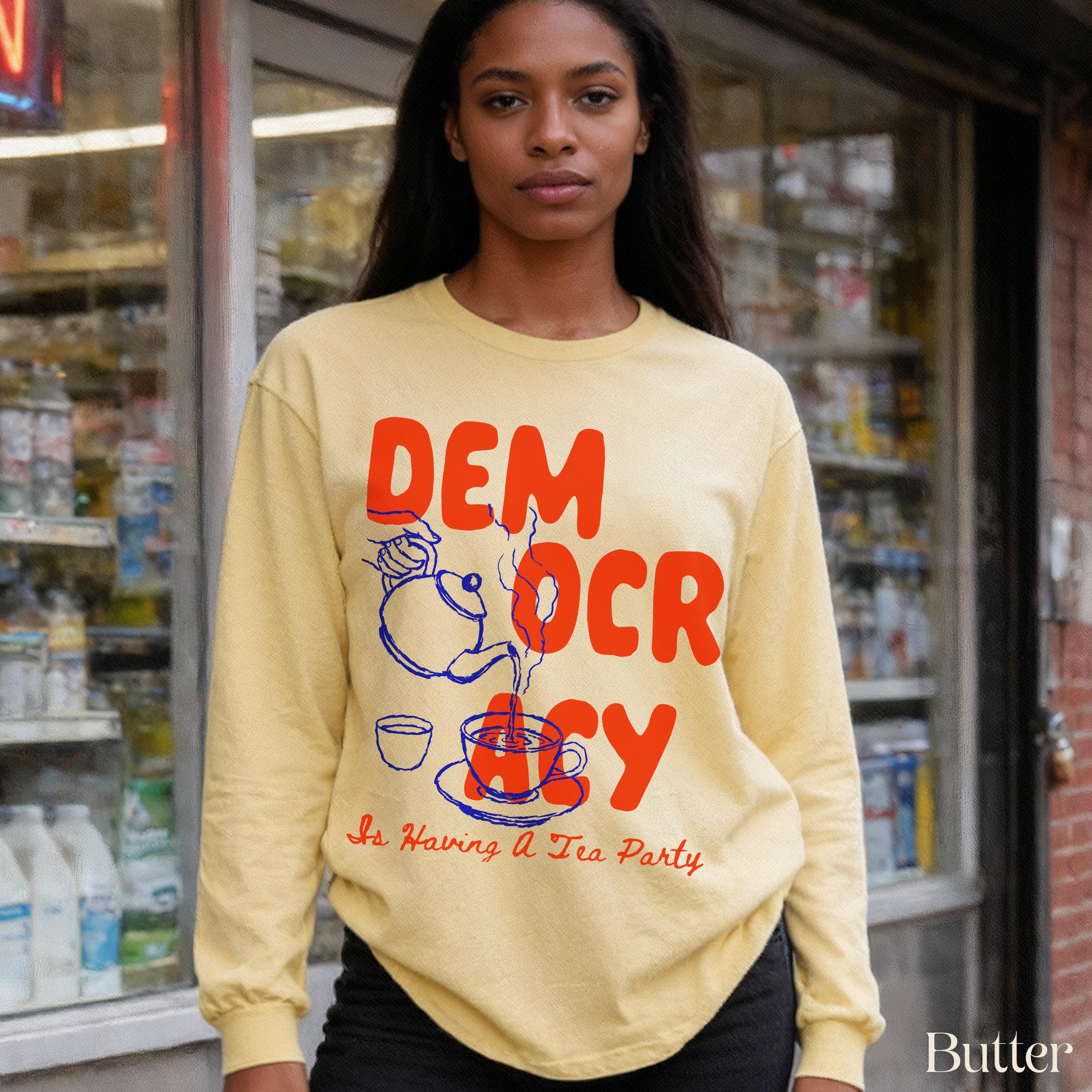Yellow long-sleeve shirt with red &amp;quot;DEMOCRACY&amp;quot; text and tea party illustration.