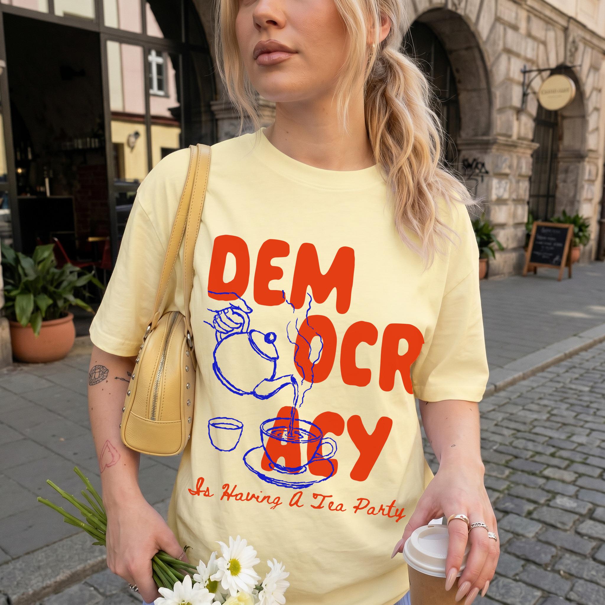 Yellow t-shirt with red text &amp;quot;Democracy Is Having A Tea Party&amp;quot; graphic.