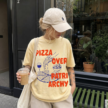 Yellow t-shirt with red text &amp;quot;Pizza Over Patriarchy&amp;quot; and graphic of pizza slices and salad.