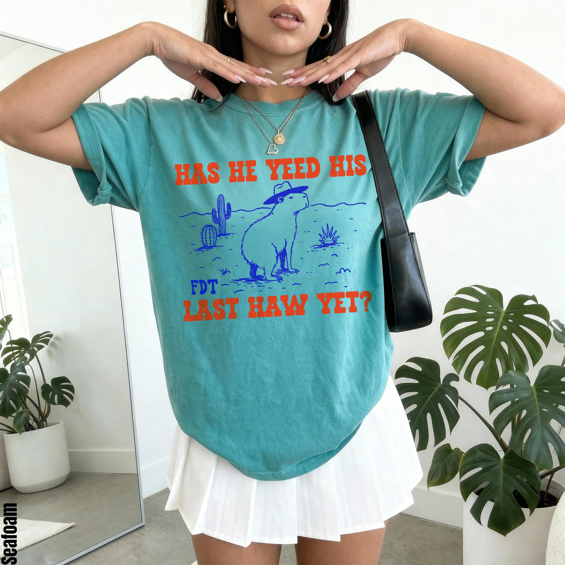 Teal t-shirt with graphic of capybara wearing hat: &amp;quot;HAS HE YEED HIS LAST HAW YET?&amp;quot;