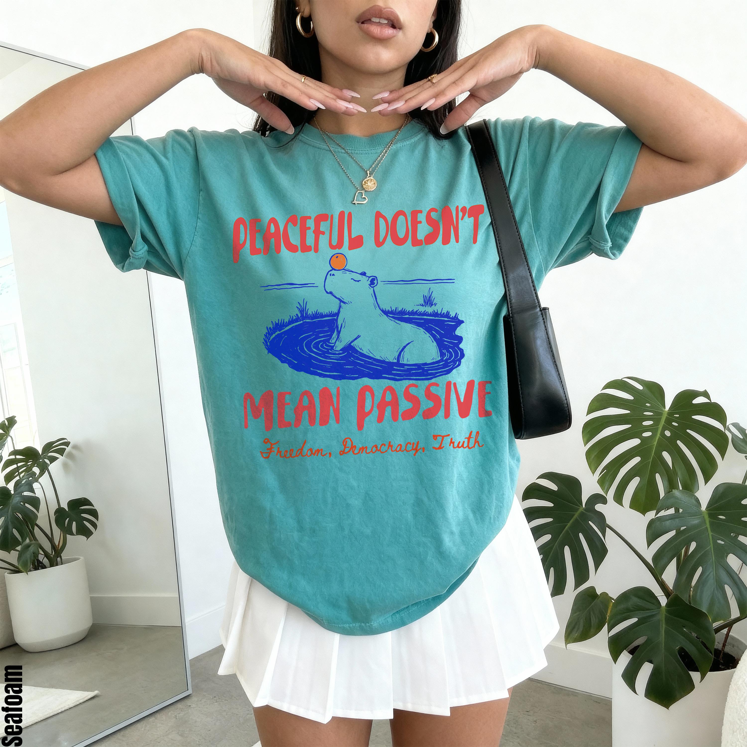 Teal t-shirt with capybara graphic and text &amp;quot;Peaceful Doesn&amp;