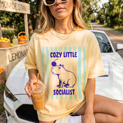 Yellow t-shirt with a capybara graphic and text &amp;quot;COZY LITTLE SOCIALIST&amp;quot;.