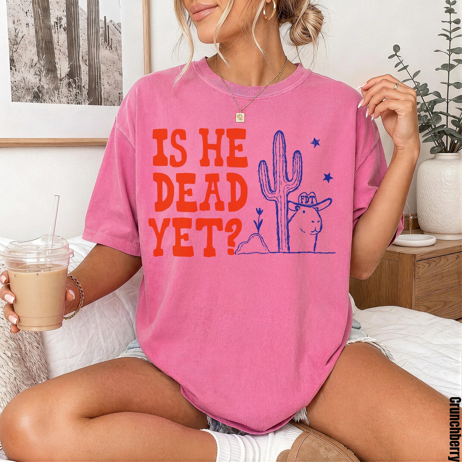 Pink t-shirt with &amp;quot;IS HE DEAD YET?&amp;quot; graphic featuring a cowboy hat-wearing prairie dog and cactus.