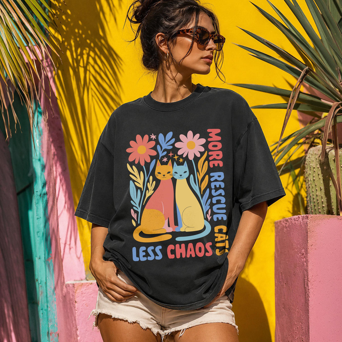 Black t-shirt with &amp;quot;More Rescue Cats, Less Chaos&amp;quot; text and colorful cat and flower graphic.