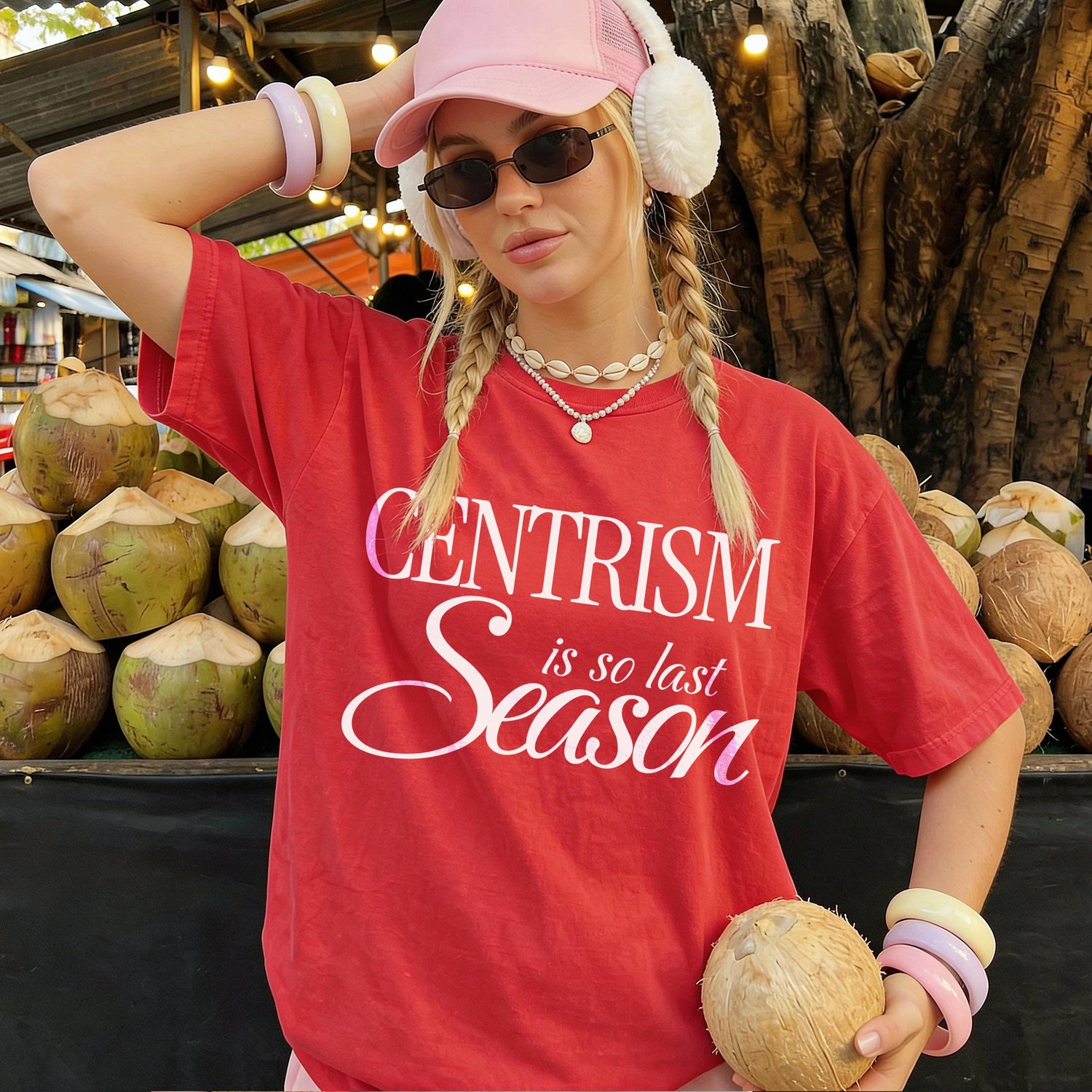Woman in red t-shirt with &amp;quot;Centrism is so last Season&amp;quot; graphic, holding coconut.
