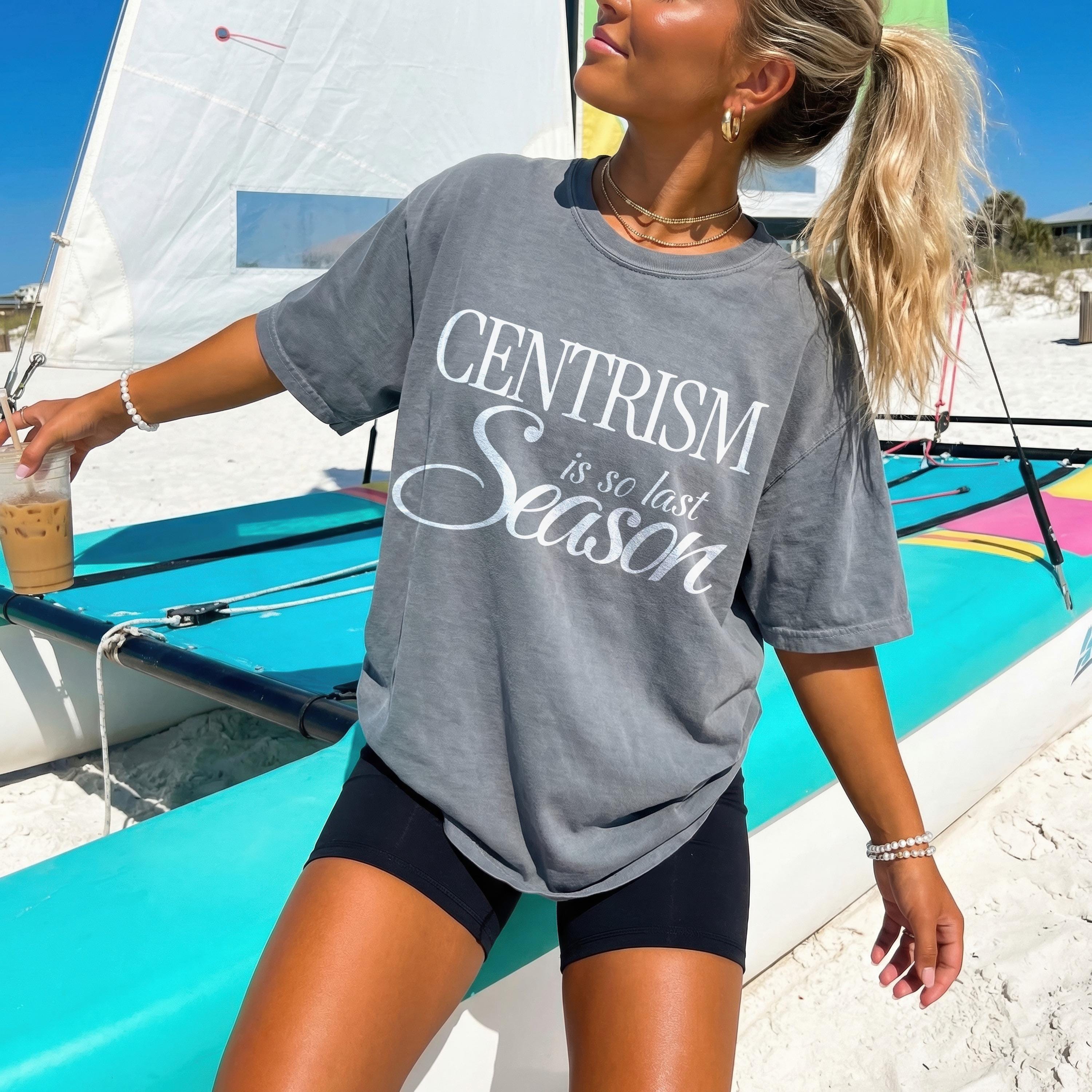 Gray t-shirt with &amp;quot;CENTRISM is so last Season&amp;quot; text, worn by a woman on a beach.
