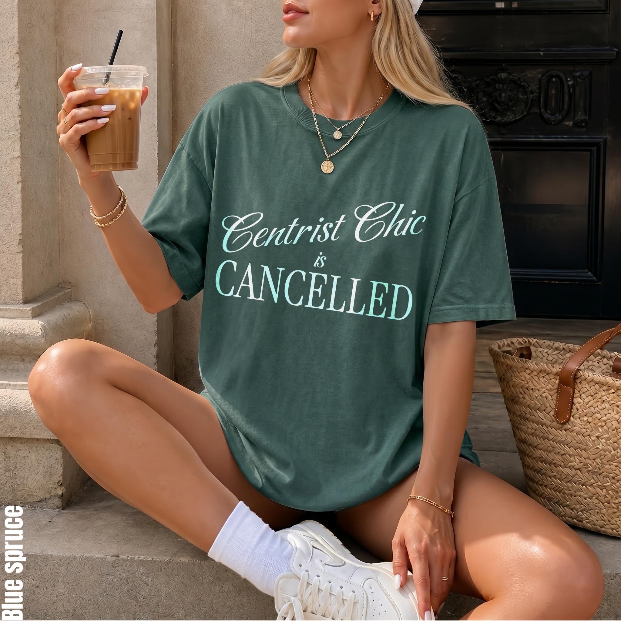 Green t-shirt with &amp;quot;Centrist Chic is CANCELLED&amp;quot; text held by a person with a drink.
