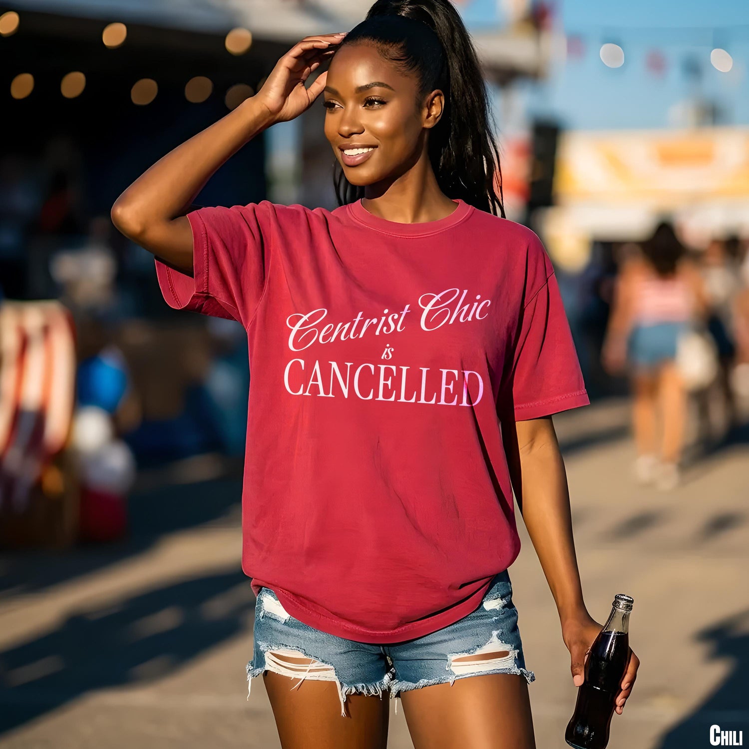 Maroon t-shirt with white text &amp;quot;Centrist Chic is CANCELLED&amp;quot; held by a woman with a bottle.