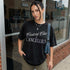 Woman wearing a black t-shirt with white text that reads "Centrist Chic is Cancelled."
