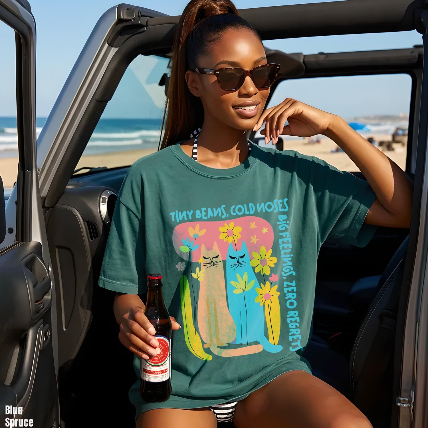 Teal t-shirt with cartoon cats and bananas; woman holds beer.