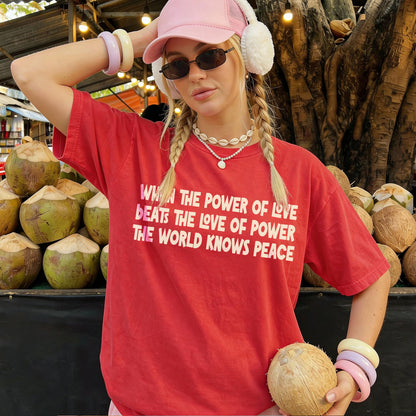 Red t-shirt with text &amp;quot;WHEN THE POWER OF LOVE BEATS THE LOVE OF POWER THE WORLD KNOWS PEACE&amp;quot;.