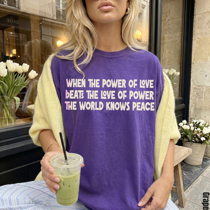 Purple t-shirt with text &amp;quot;When the power of love beats the love of power the world knows peace&amp;quot;.