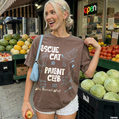 Brown t-shirt with &amp;quot;RESCUE CAT PARENT CLUB&amp;quot; and &amp;quot;Who Rescued Who?&amp;quot; text.