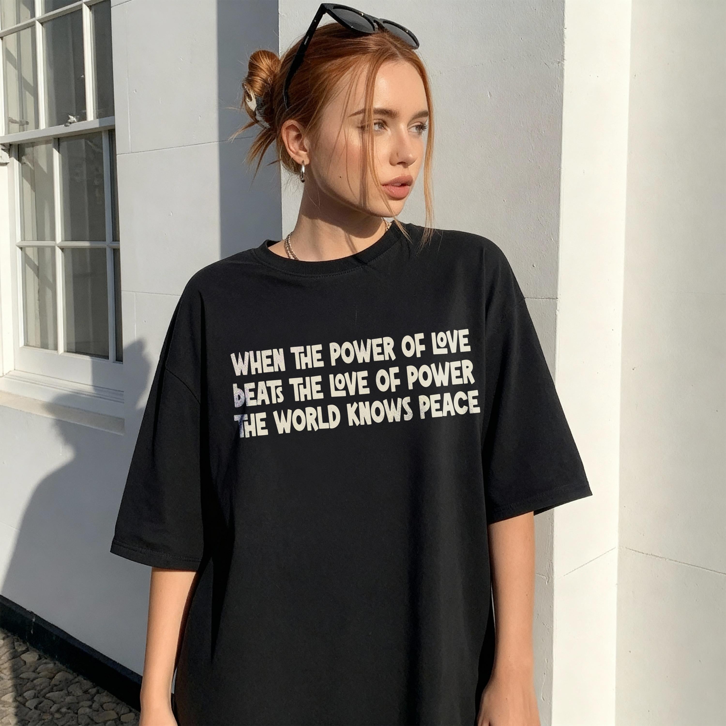 Black t-shirt with white text &amp;quot;When the power of love beats the love of power, the world knows peace.&amp;quot;