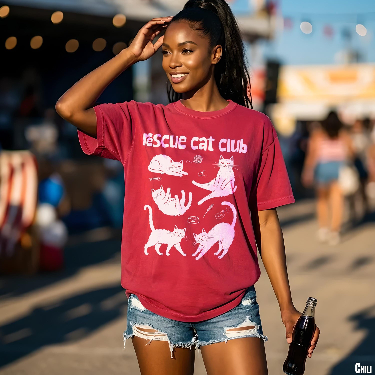 Woman in maroon t-shirt with multiple pink cat illustrations and &amp;quot;Rescue Cat Club&amp;quot; text.