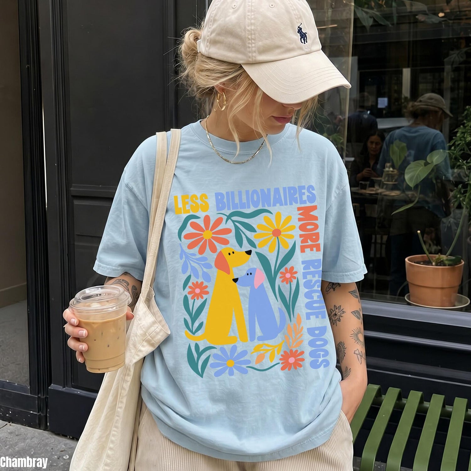 Blue t-shirt with &amp;quot;Less Billionaires More Rescue Dogs&amp;quot; text and colorful dog and flower graphics.