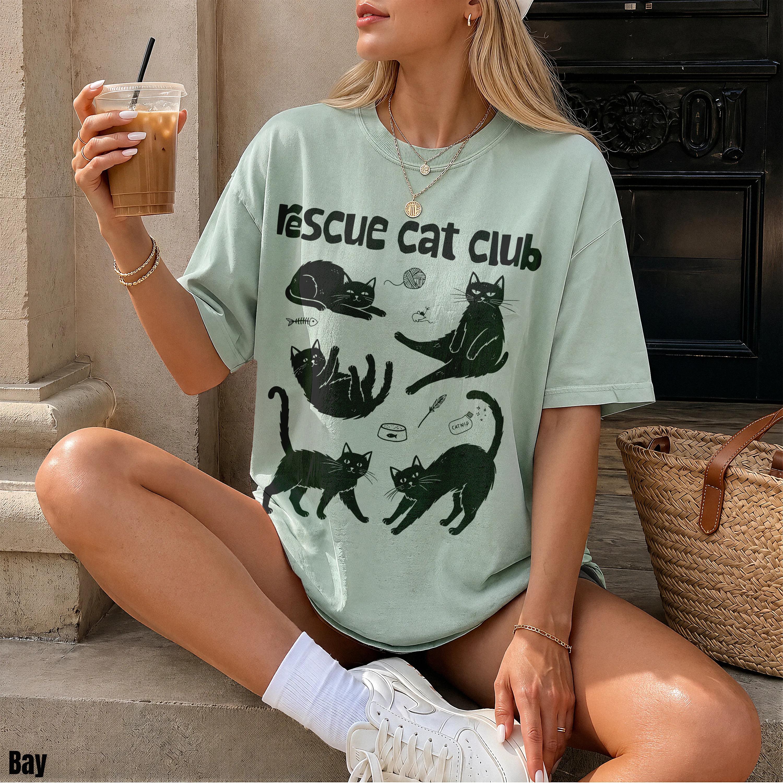 Woman wearing mint green t-shirt with &amp;quot;Rescue Cat Club&amp;quot; and cat illustrations.