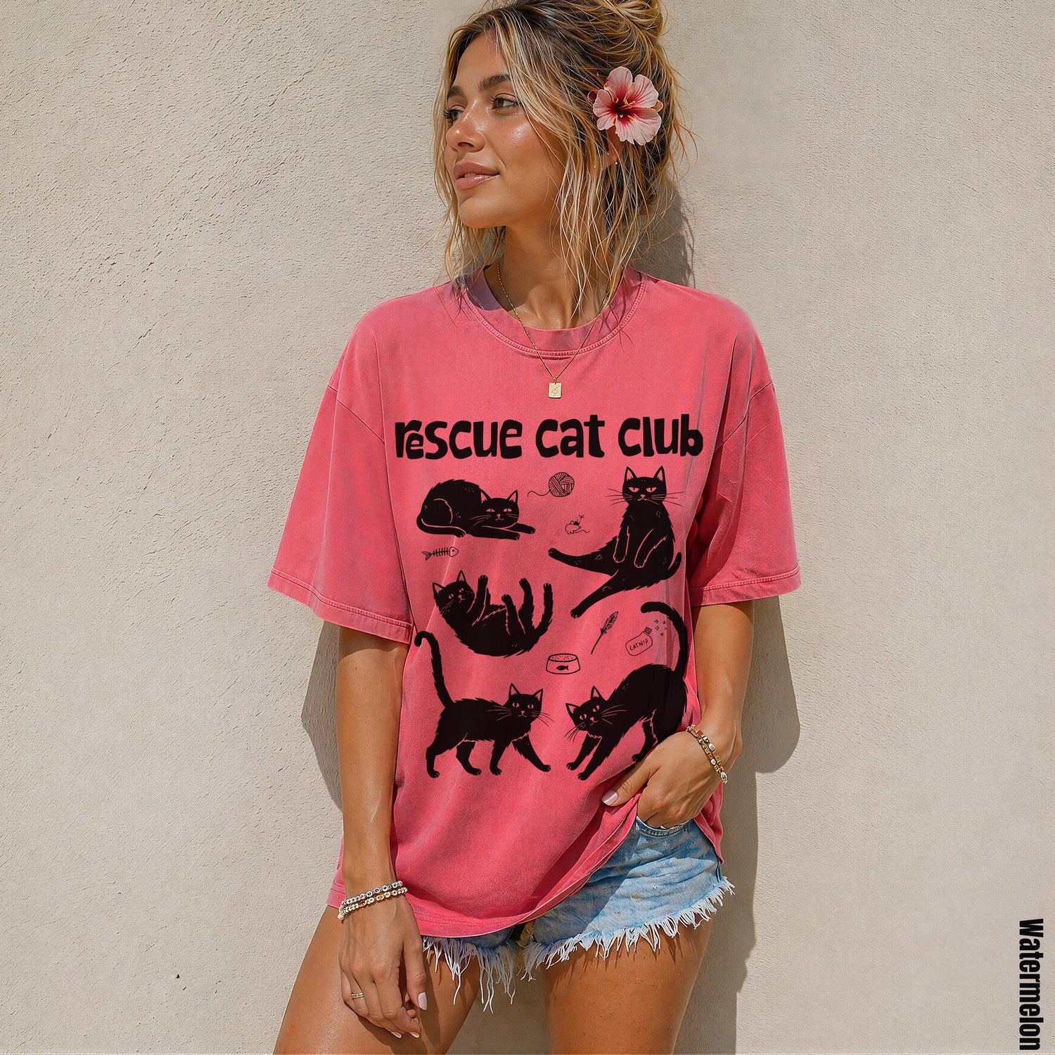 Woman wearing a faded pink t-shirt with &amp;quot;Rescue Cat Club&amp;quot; and cat illustrations.