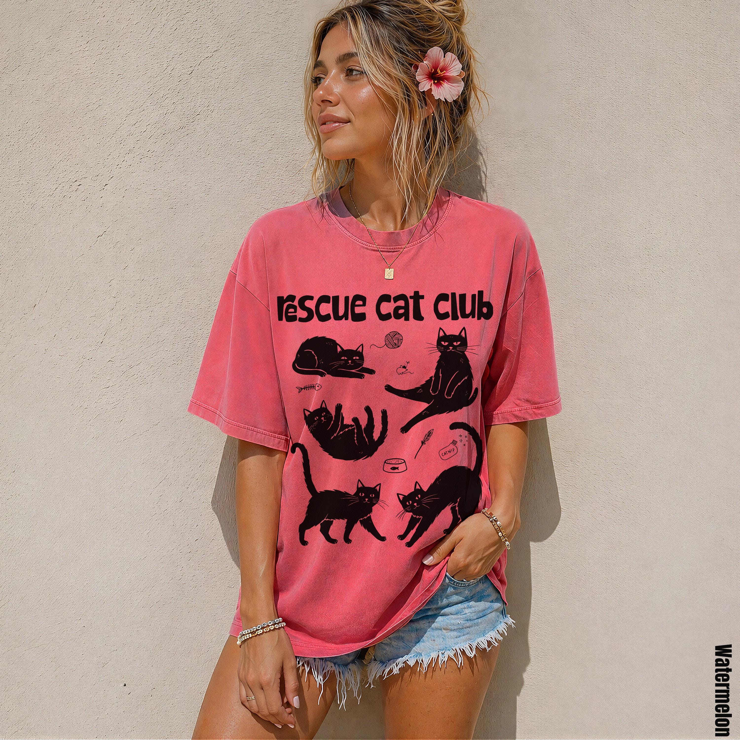 Woman wearing a faded pink t-shirt with &amp;quot;Rescue Cat Club&amp;quot; and cat illustrations.