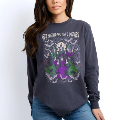 Long sleeve t-shirt with graphic of witches, cats, bats, and moon. Text reads &amp;quot;God forbid we have hobbies&amp;quot;.