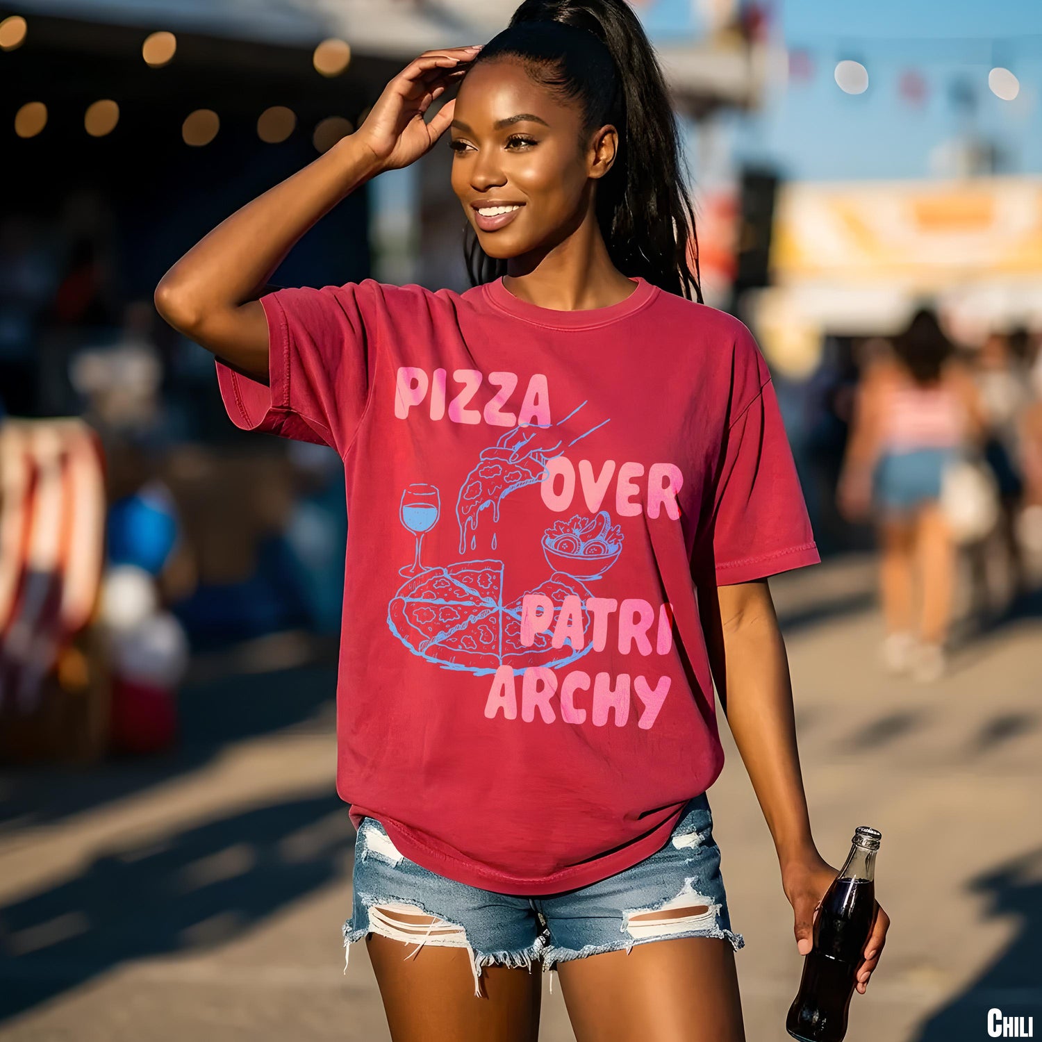 Woman wearing red t-shirt with &amp;quot;Pizza Over Patriarchy&amp;quot; graphic and holding a glass bottle.