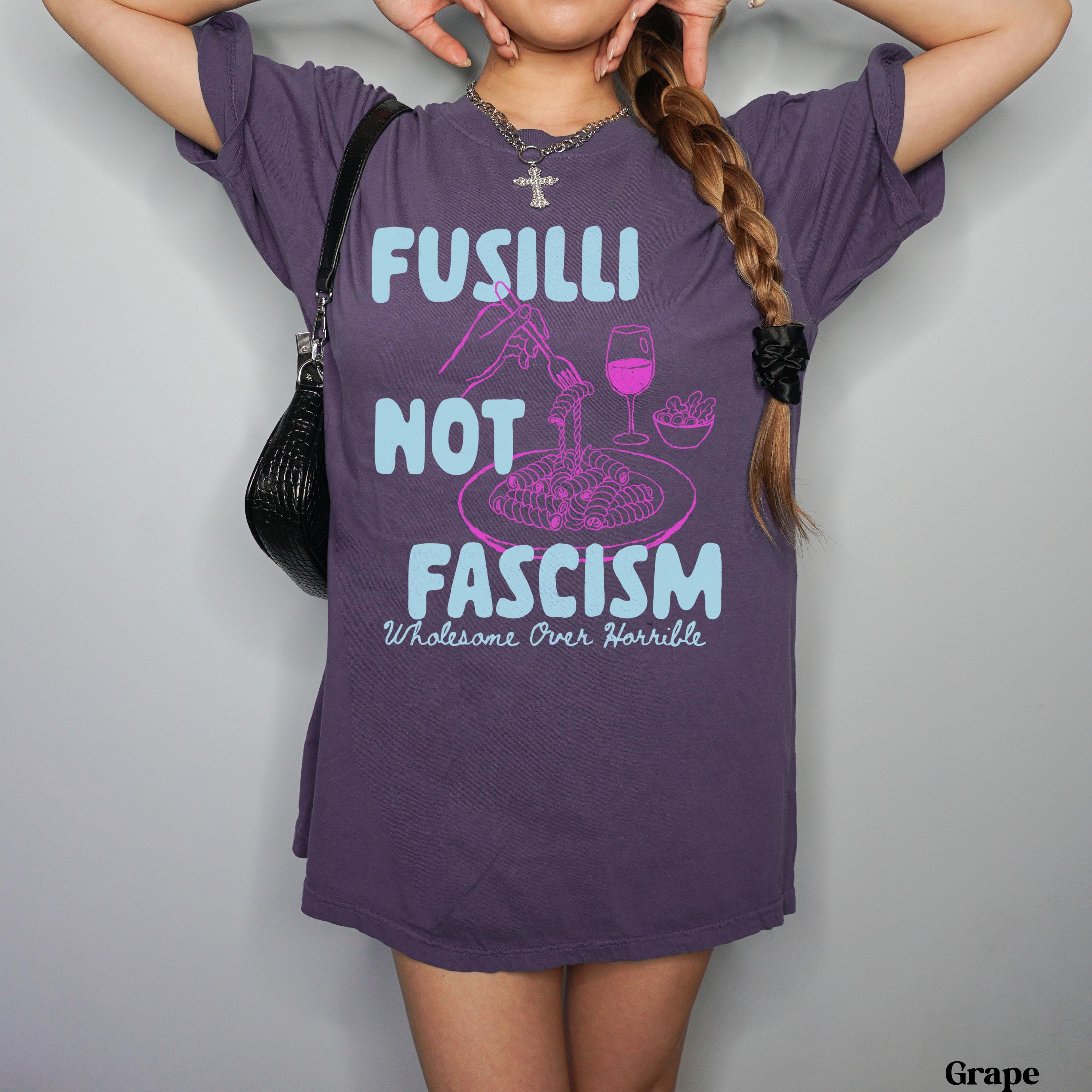Purple t-shirt with text &amp;quot;Fusilli Not Fascism Wholesome Over Horrible&amp;quot;.