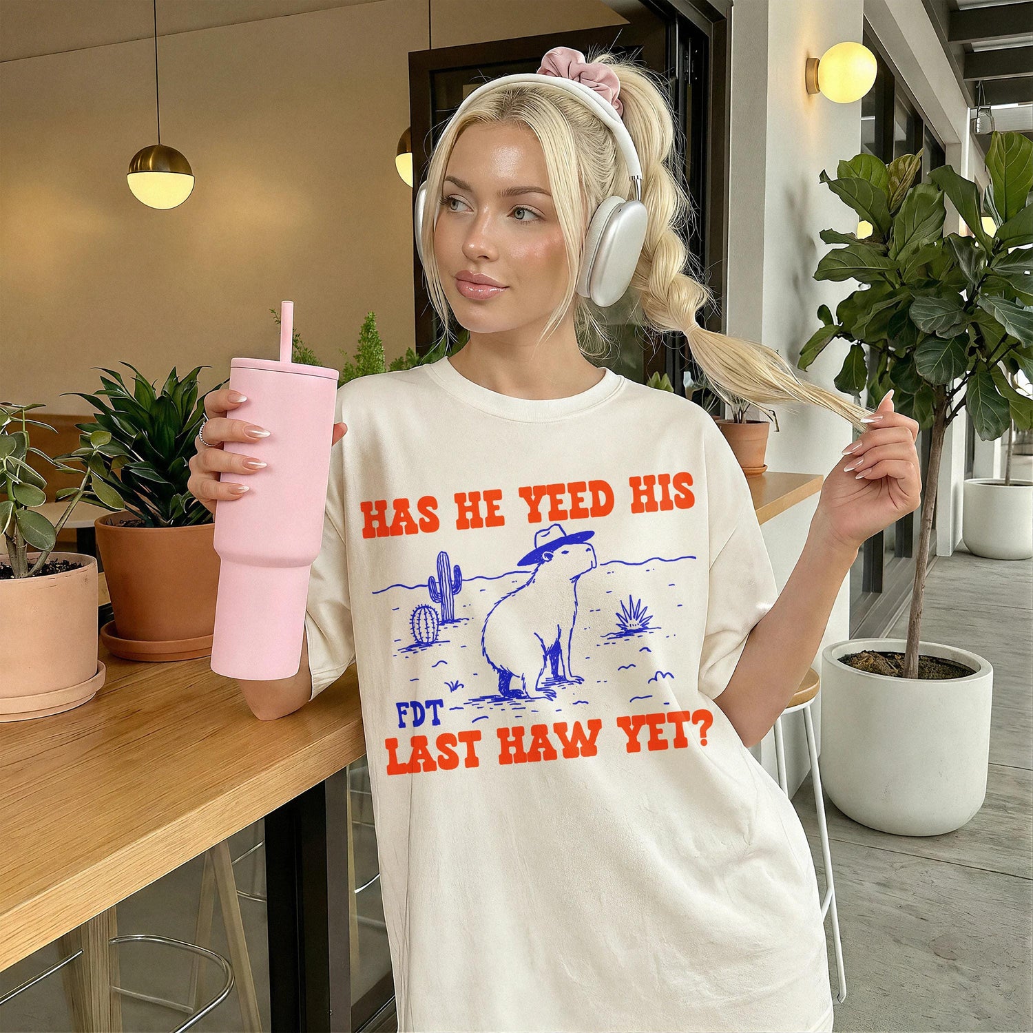 Cream t-shirt with graphic &amp;quot;HAS HE YEED HIS FDT LAST HAW YET?&amp;quot; and a capybara.