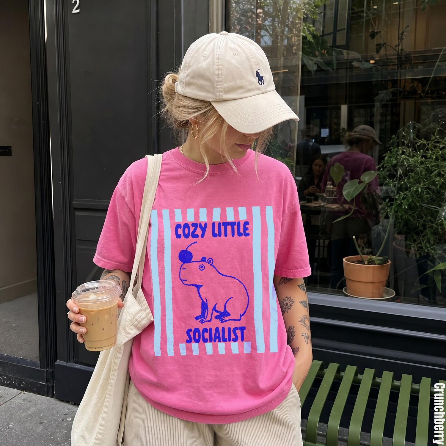 Woman wearing pink t-shirt with capybara and text graphic.