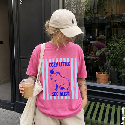 Woman wearing pink t-shirt with capybara and text graphic.