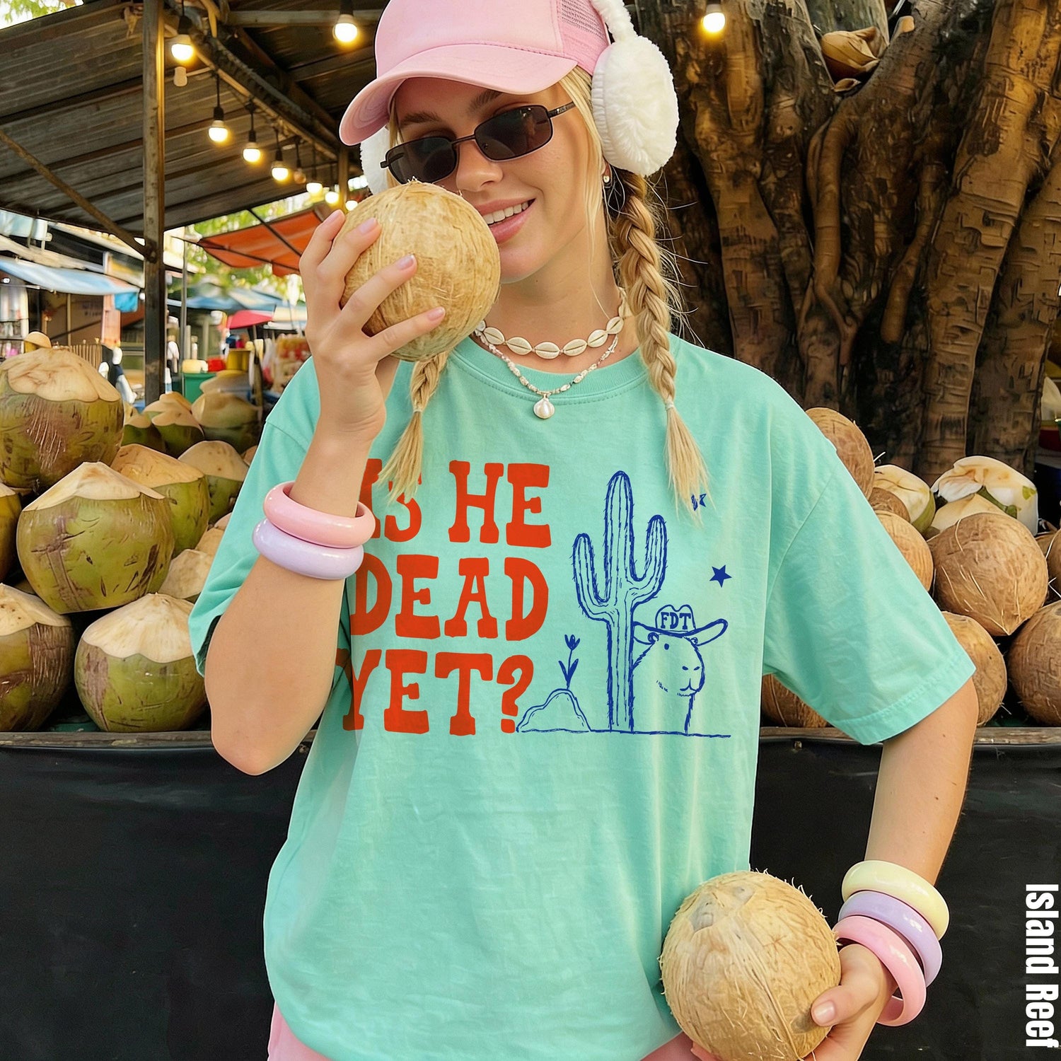 Mint green t-shirt with &amp;quot;IS HE DEAD YET?&amp;quot; text and desert graphic.
