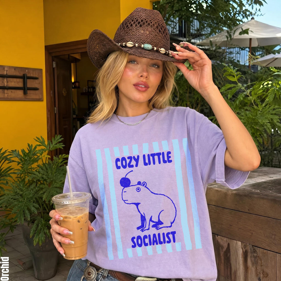 Purple t-shirt with capybara graphic and text: &amp;quot;Cozy Little Socialist.&amp;quot;