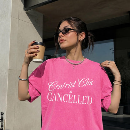 Woman wearing pink tee with text &amp;quot;Centrist Chic is CANCELLED&amp;quot; and holding coffee cup.