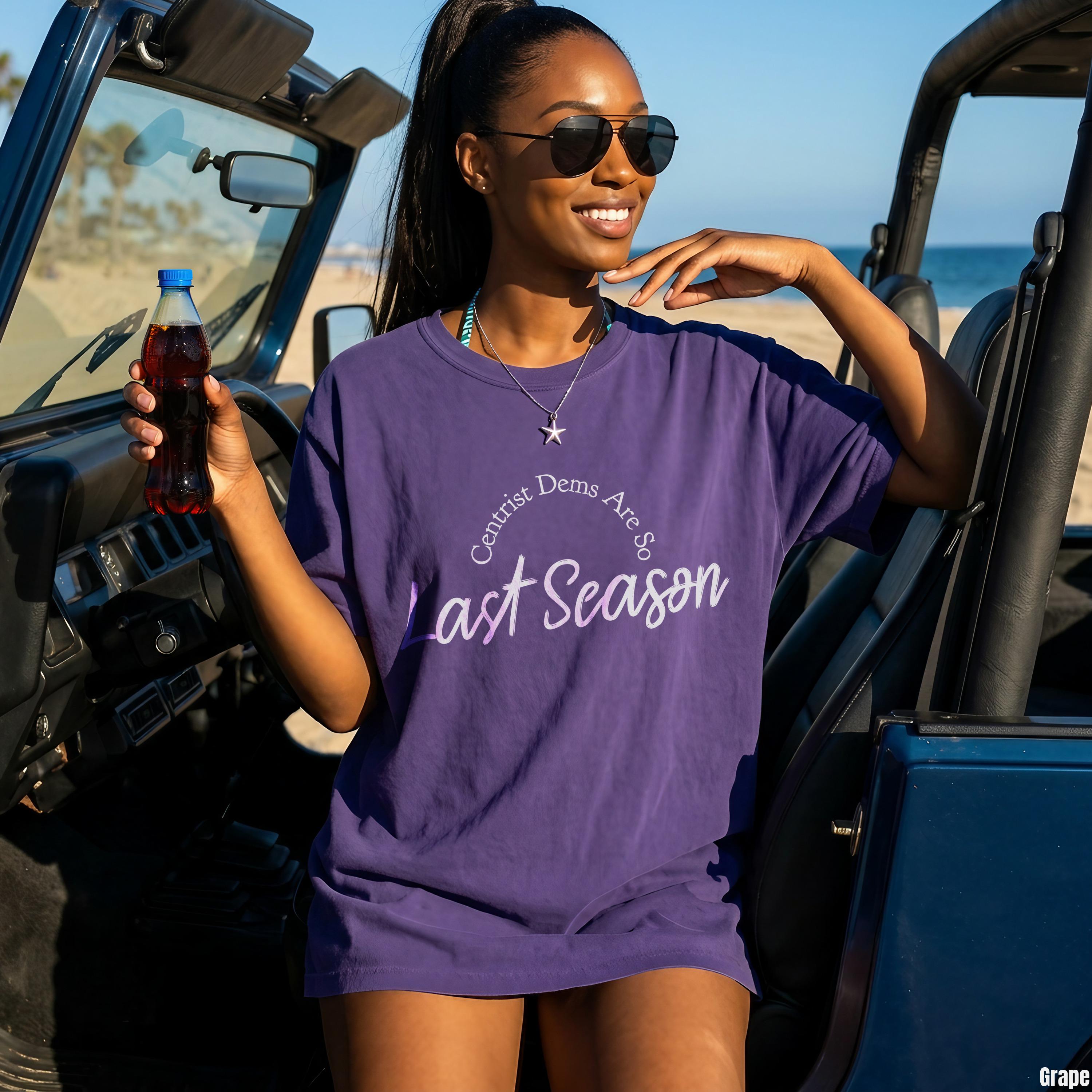 Woman in purple t-shirt with text &amp;quot;Centrist Dems Are So Last Season&amp;quot; holding soda bottle.
