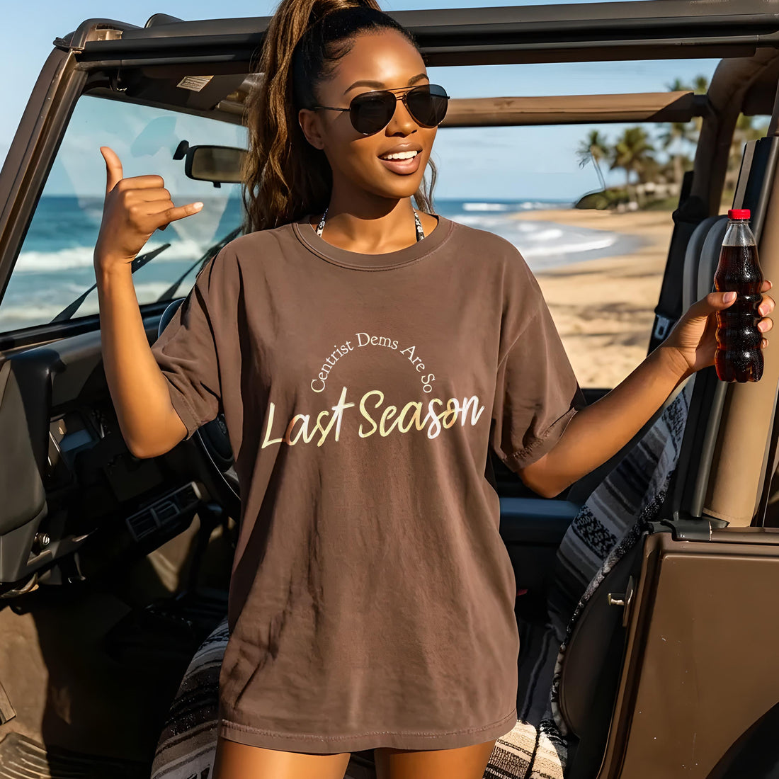 Woman in brown t-shirt with text &amp;quot;Centrist Dems Are So Last Season&amp;quot; holding soda.
