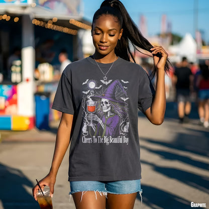 Dark grey t-shirt with skeleton witch graphic and &amp;quot;Cheers To The Big Beautiful Day&amp;quot; text.