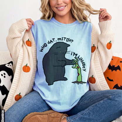 Light blue t-shirt with black cat saying &amp;quot;WHO DAT, MITCH?&amp;quot; to a zombie hand that says &amp;quot;I&amp;