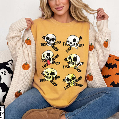Mustard yellow sweatshirt with graphic skulls and text, worn by a woman.