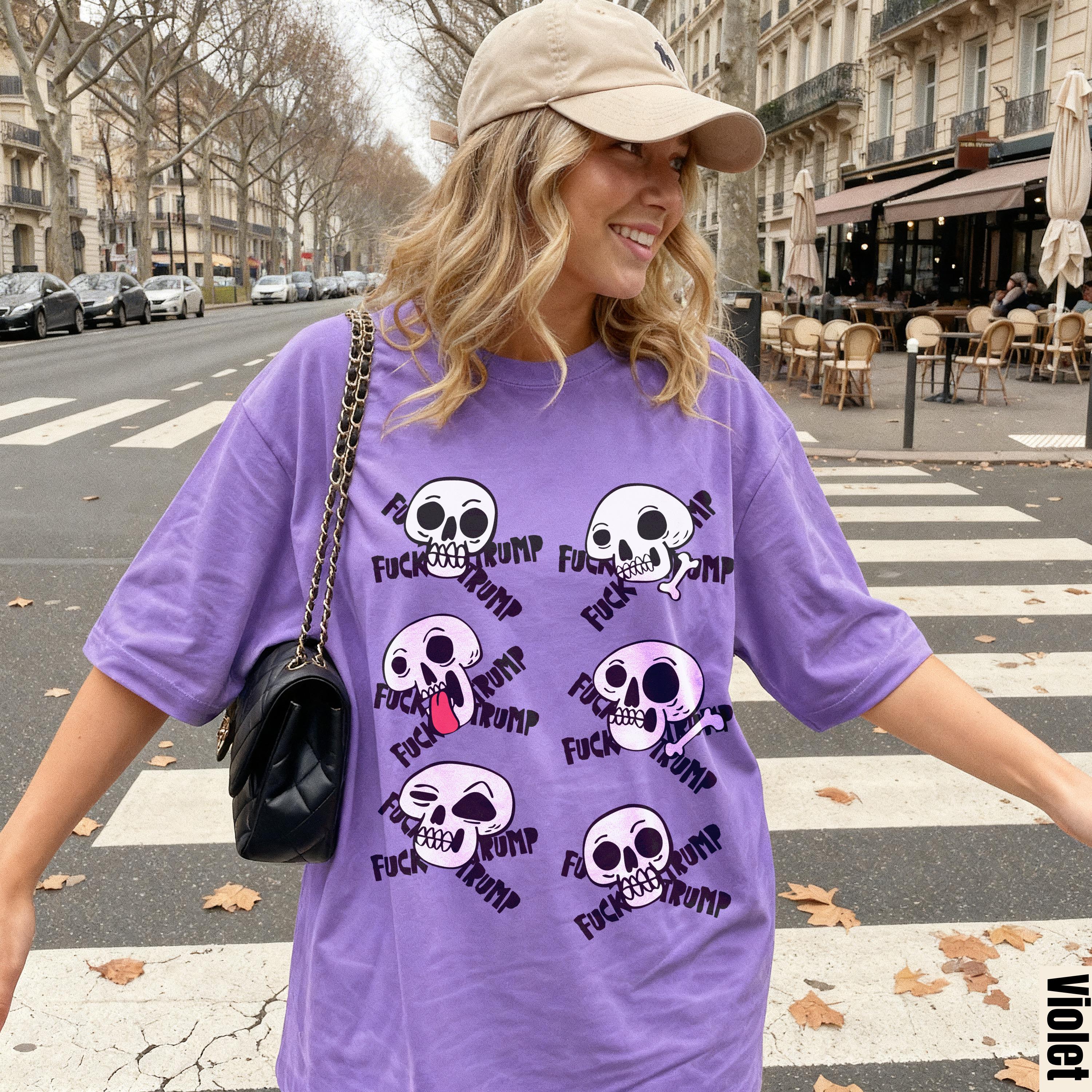 Purple t-shirt with skull graphic and text, worn by woman on city street.
