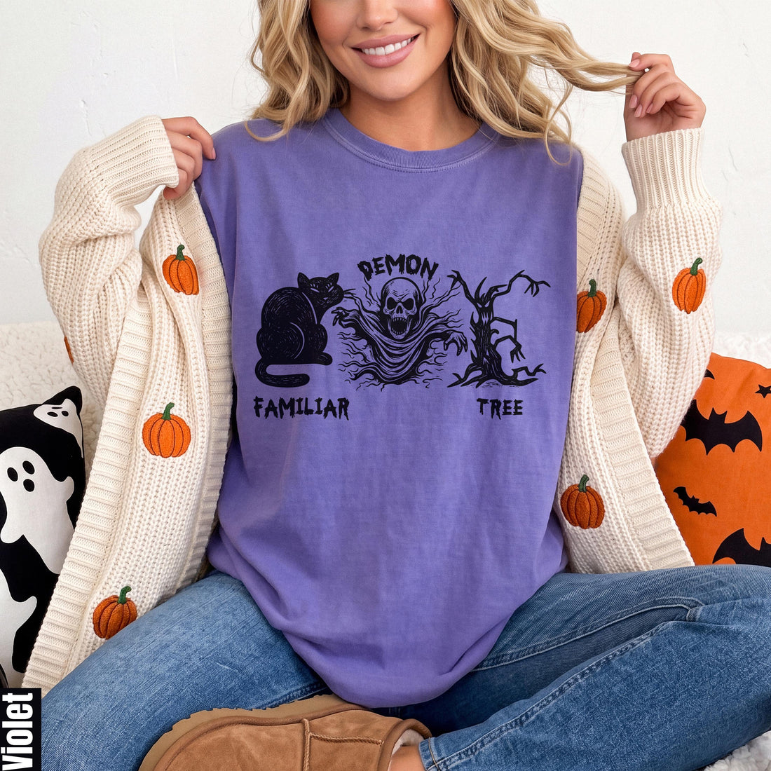 Purple t-shirt with black cat, ghost, and tree Halloween graphic.