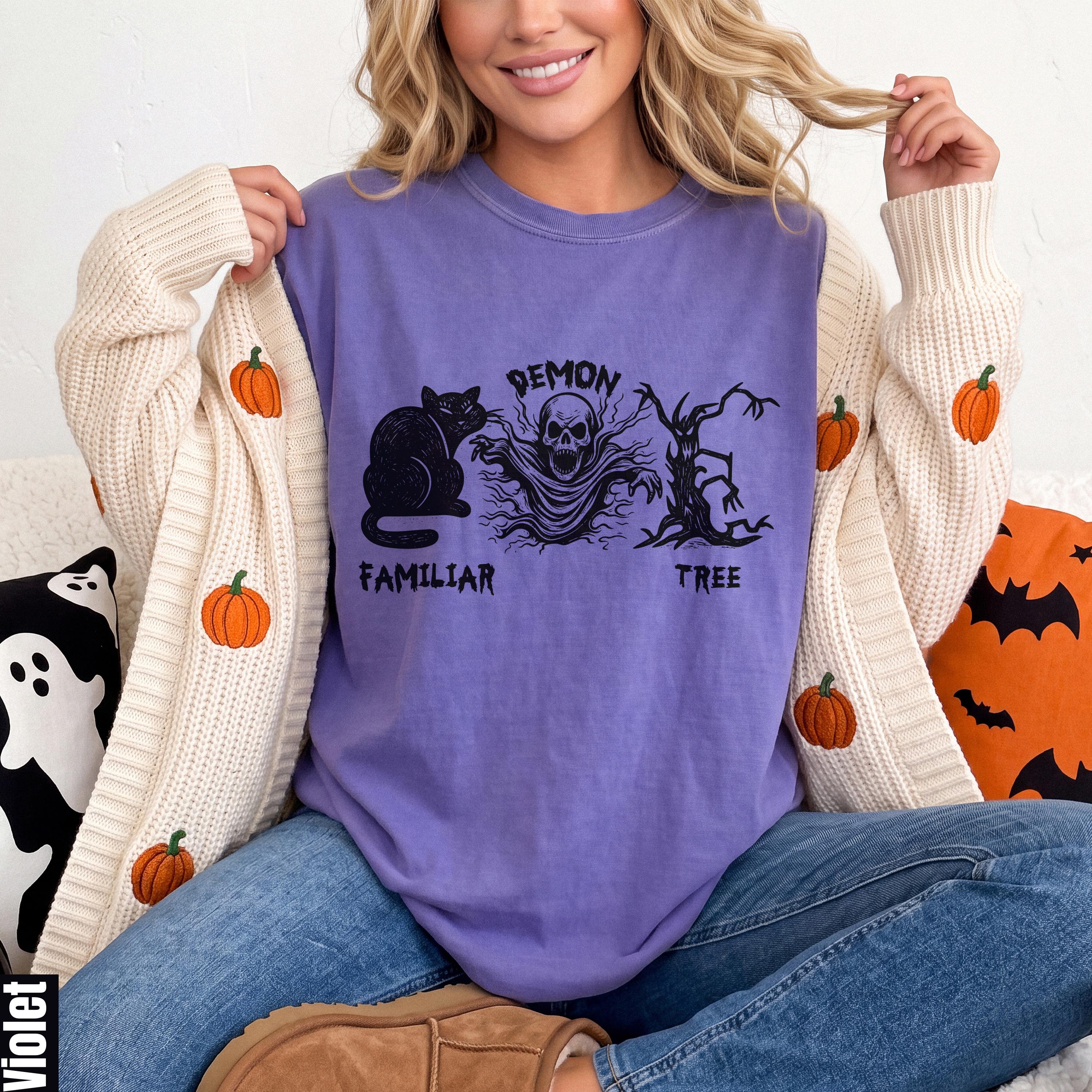 Purple t-shirt with black cat, ghost, and tree Halloween graphic.
