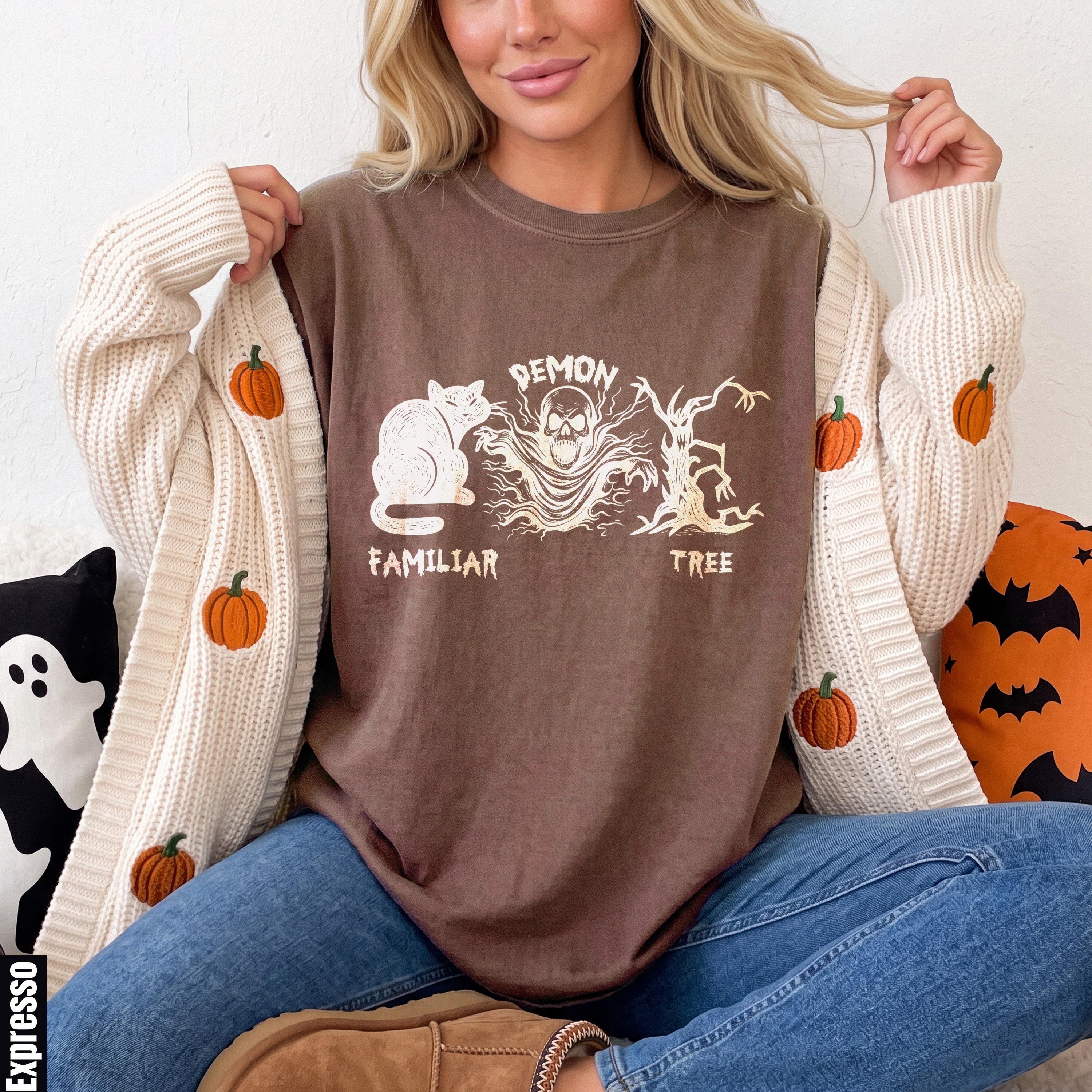 Brown t-shirt with white cat, skull ghost, and barren tree prints.