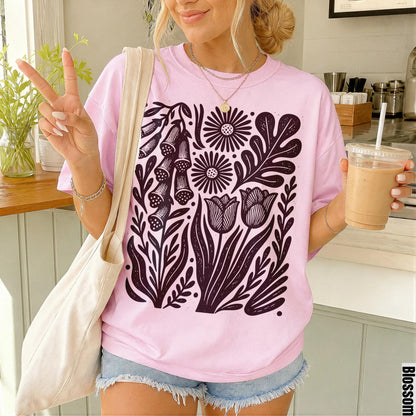 Pink t-shirt with dark floral print, worn with denim shorts and a tote bag.