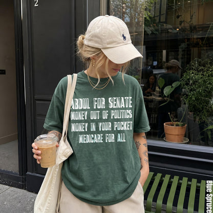 Green t-shirt with text: Abdul for Senate, Money out of politics, Money in your pocket, Medicare for all.