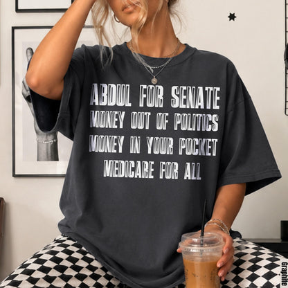 Dark grey t-shirt with white text: Abdul for Senate, Money Out of Politics, Money In Your Pocket, Medicare For All.